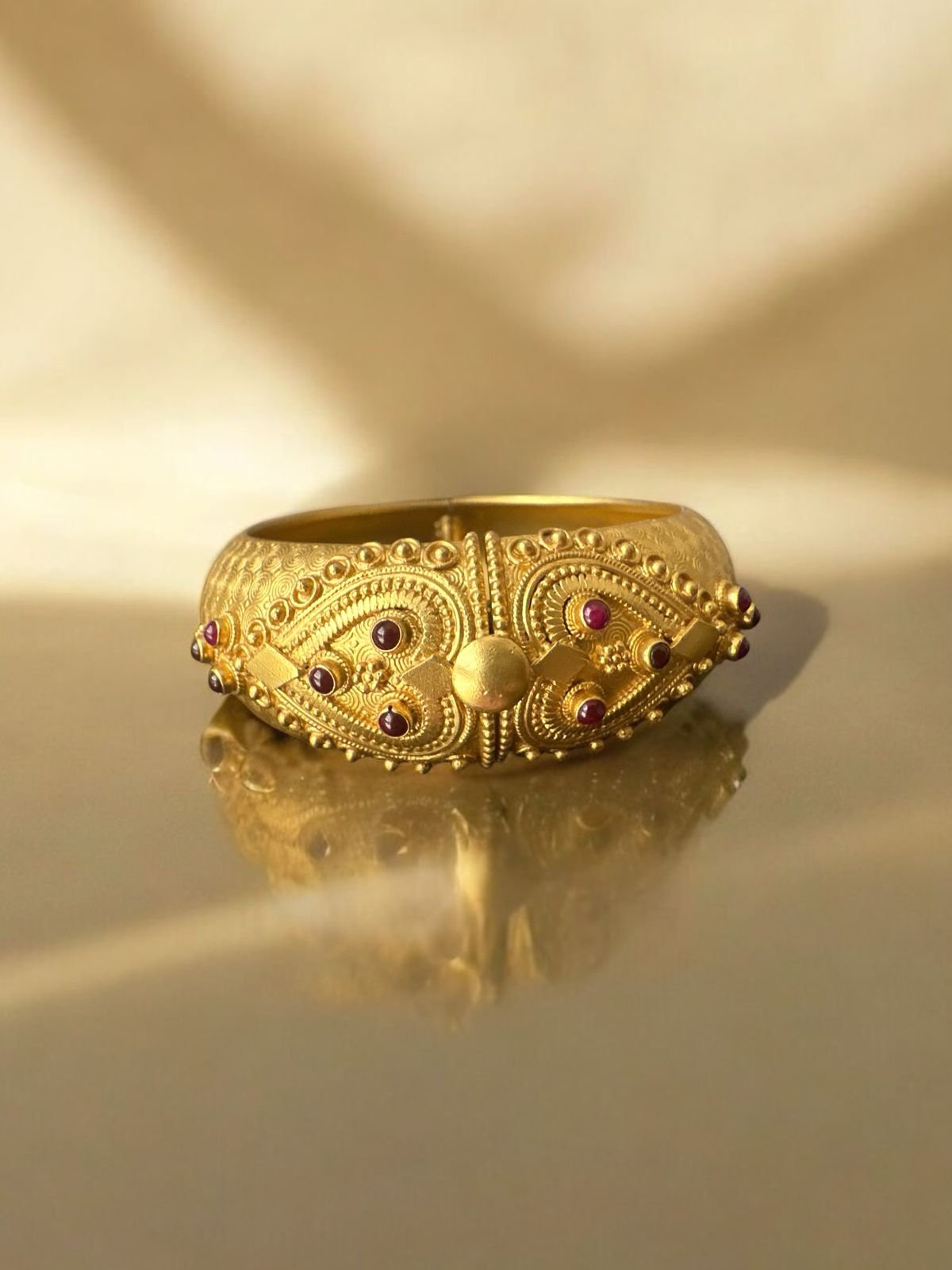 Single bangle with gold polish red pota stones